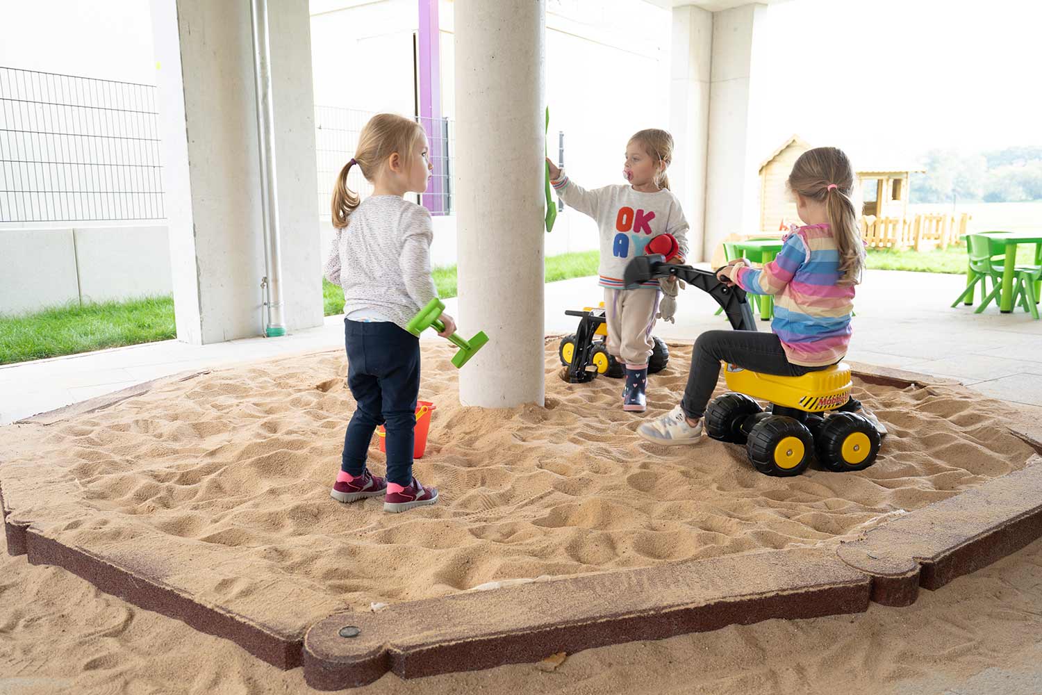Kita Wolkersdorf Sandkasten Aufnahme von drei Mädchen in einem Sandkasten